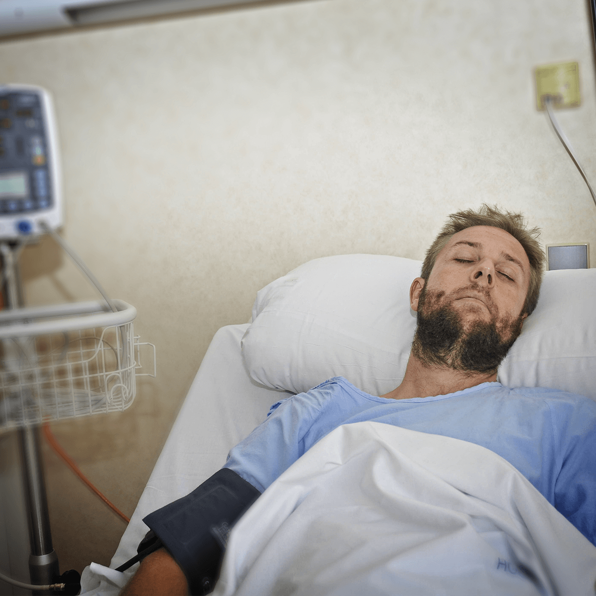 bigstock-Injured-Man-Lying-In-Bed-Hospi-96662984